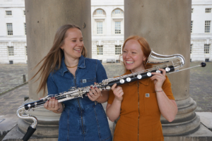 Hannah Shilvock & Viola Lenzi standing outside holding bass clarinet